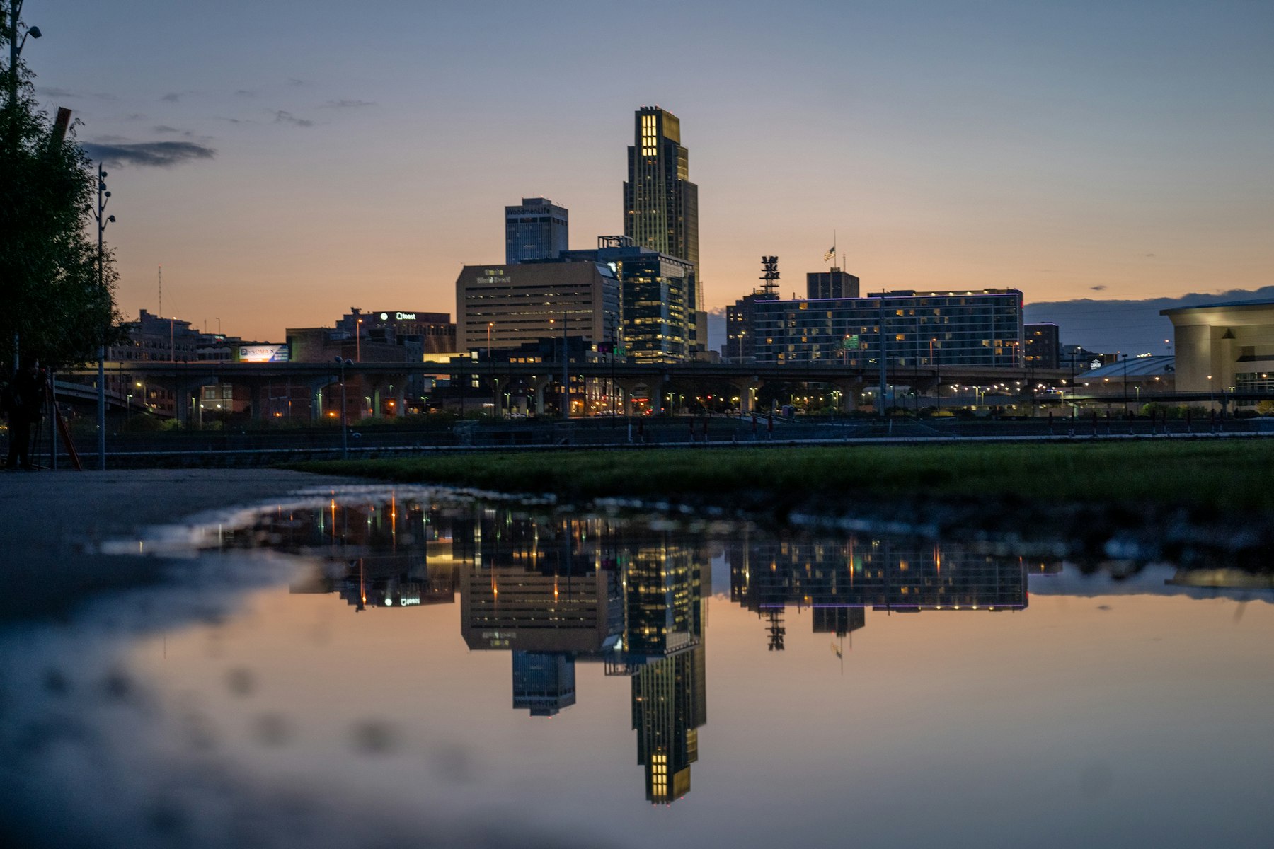The downtown Omaha skyline reflected in the water below it